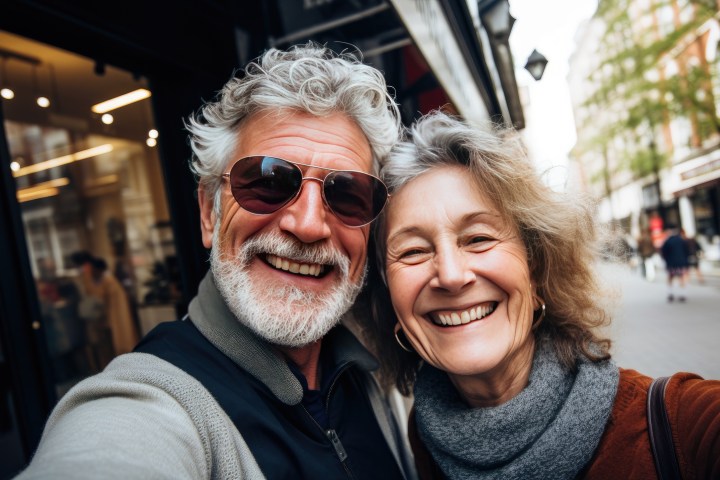 a man wearing glasses and smiling at the camera